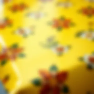 Close-up of a yellow vinyl tablecloth featuring a decorative floral pattern.