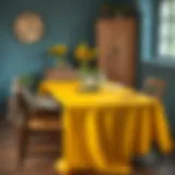 A vibrant yellow vinyl tablecloth draped over a rustic wooden table.