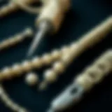 Close-up of pearl knotting tools including thread and needles