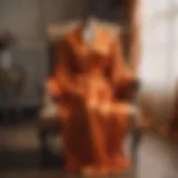 Luxurious orange satin robe draped elegantly on a vintage chair