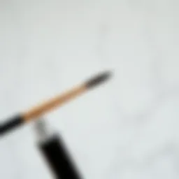 Close-up of a thin angled eyebrow brush against a marble background