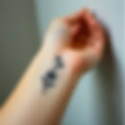 Delicate small flower tattoo design on a wrist